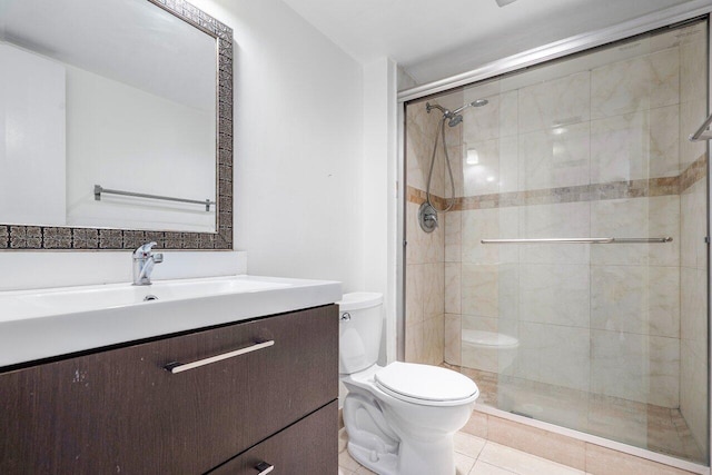 bathroom with vanity, toilet, a shower with shower door, and tile patterned flooring