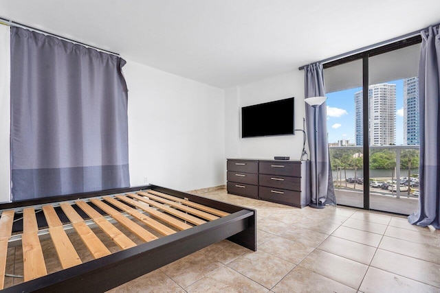 unfurnished bedroom with floor to ceiling windows, access to outside, and light tile patterned floors