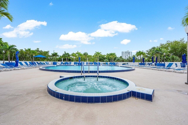 view of swimming pool with a community hot tub and a patio area