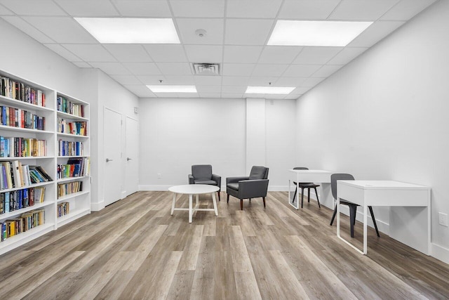 sitting room with light hardwood / wood-style flooring and a drop ceiling