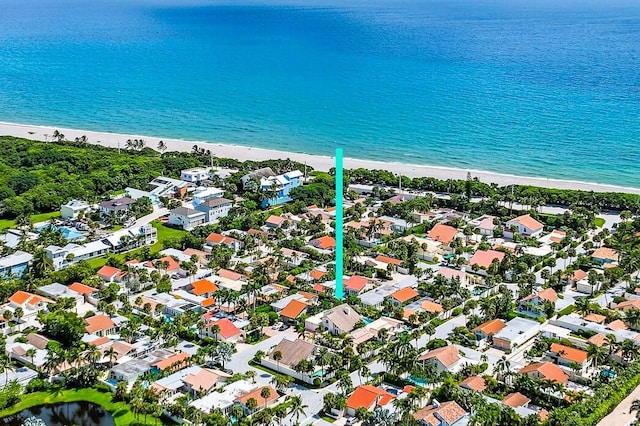 birds eye view of property with a water view and a beach view