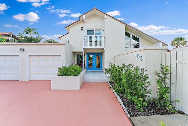 mediterranean / spanish home with a balcony, a garage, and french doors