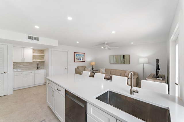 kitchen with white cabinetry, sink, tasteful backsplash, stainless steel dishwasher, and ceiling fan