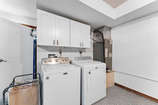 clothes washing area featuring cabinets and washer and clothes dryer