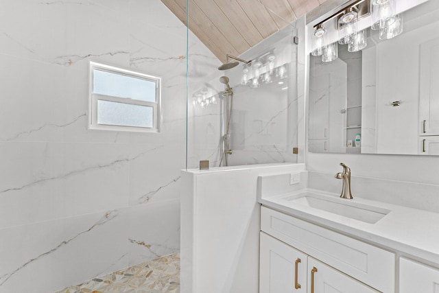 bathroom featuring vanity, vaulted ceiling, a tile shower, and wood ceiling