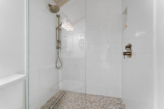 bathroom featuring toilet and a tile shower