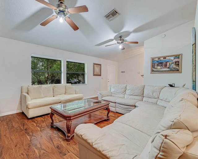 living room with dark wood-type flooring, vaulted ceiling, and ceiling fan