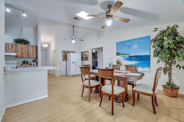 dining room featuring ceiling fan with notable chandelier, light wood-type flooring, and lofted ceiling with skylight