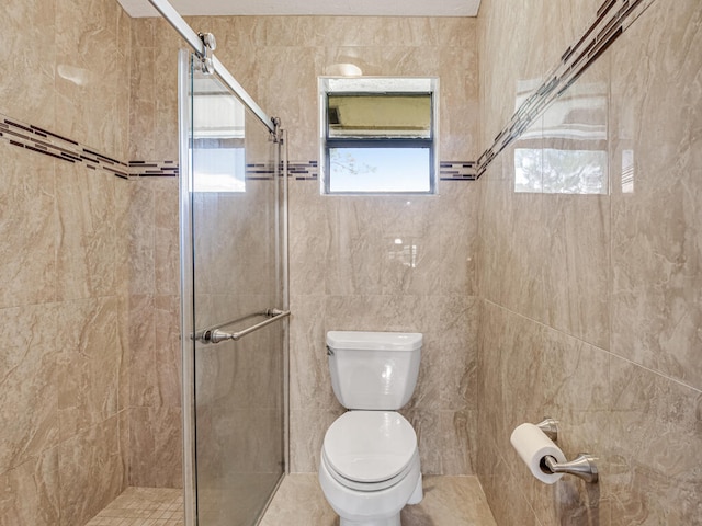 bathroom with a shower with shower door and toilet