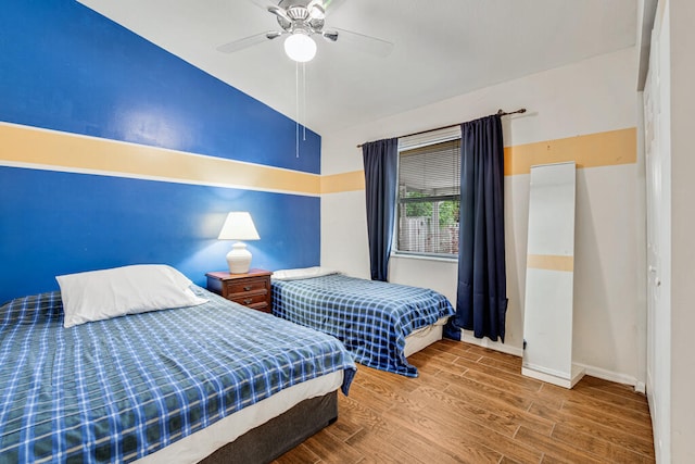 bedroom with lofted ceiling, wood-type flooring, and ceiling fan