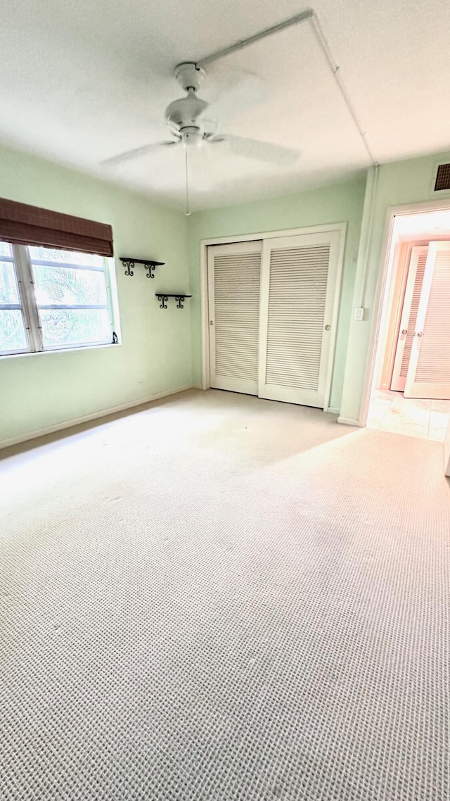 unfurnished bedroom featuring light colored carpet and ceiling fan