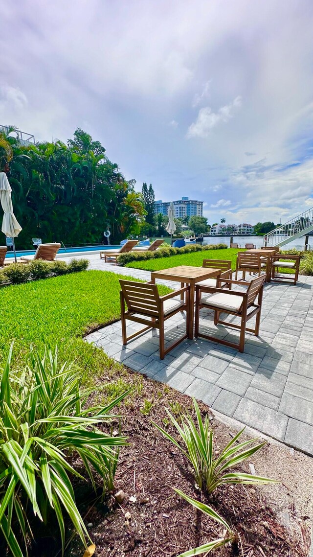 view of home's community with a lawn, a patio, and a swimming pool