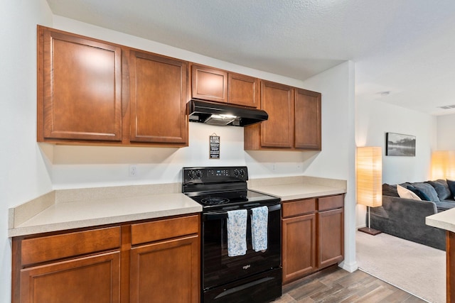 kitchen featuring a textured ceiling, dark wood-type flooring, and black range with electric stovetop