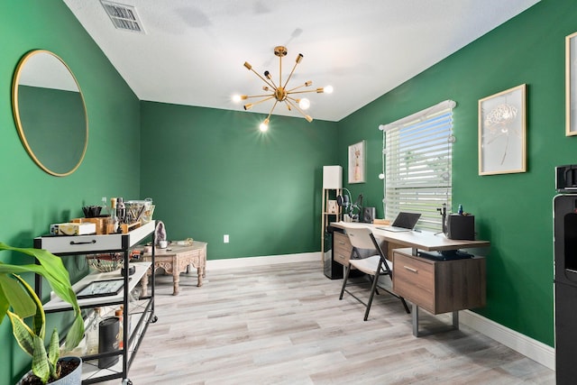 office space with a textured ceiling, light hardwood / wood-style floors, and an inviting chandelier