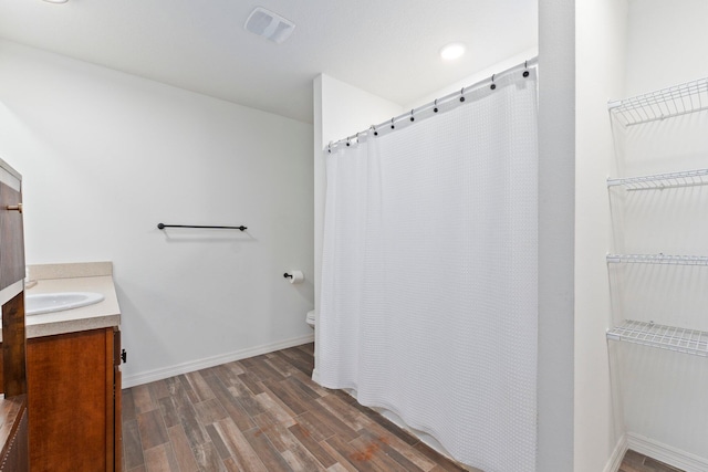 bathroom featuring wood-type flooring, vanity, toilet, and a shower with curtain