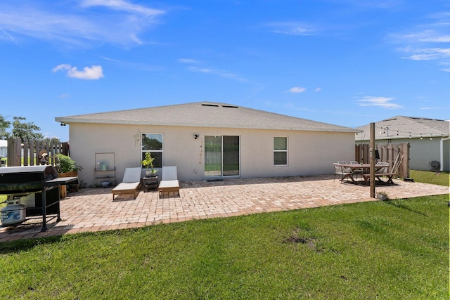 rear view of house with a yard and a patio