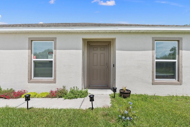 view of exterior entry featuring a yard