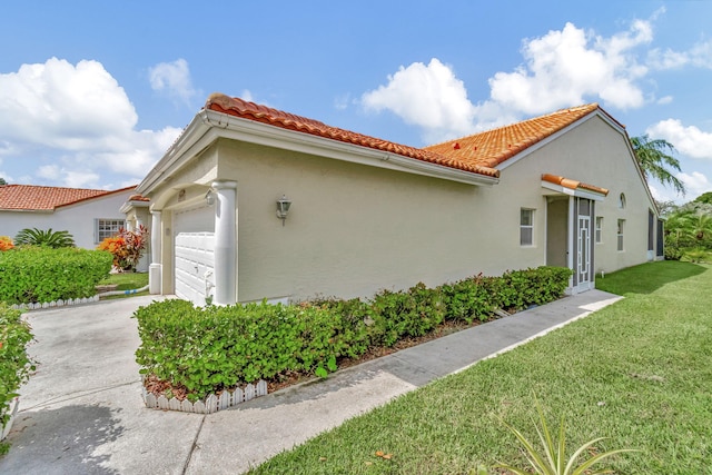 view of side of home with a garage and a lawn