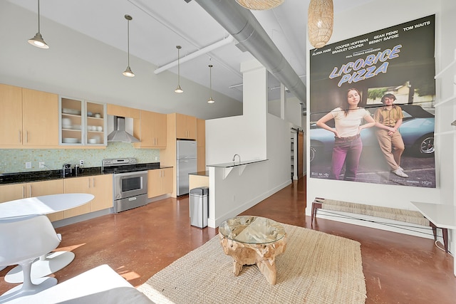 interior space with wall chimney exhaust hood, tasteful backsplash, hanging light fixtures, stainless steel appliances, and light brown cabinets