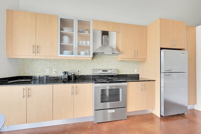 kitchen with stainless steel appliances, dark stone counters, wall chimney exhaust hood, and light brown cabinetry