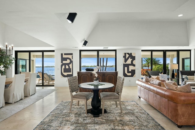 living room featuring a water view, lofted ceiling, plenty of natural light, and an inviting chandelier