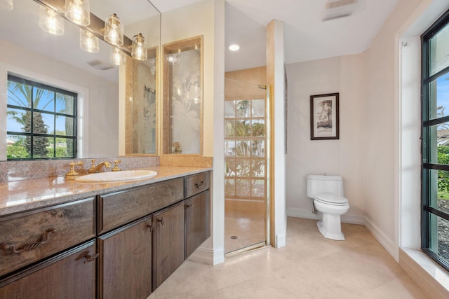 bathroom with visible vents, toilet, vanity, baseboards, and walk in shower