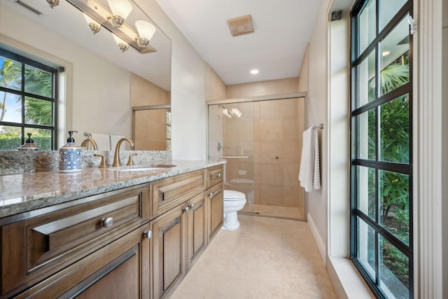 bathroom featuring toilet, vanity, visible vents, tile patterned floors, and a stall shower