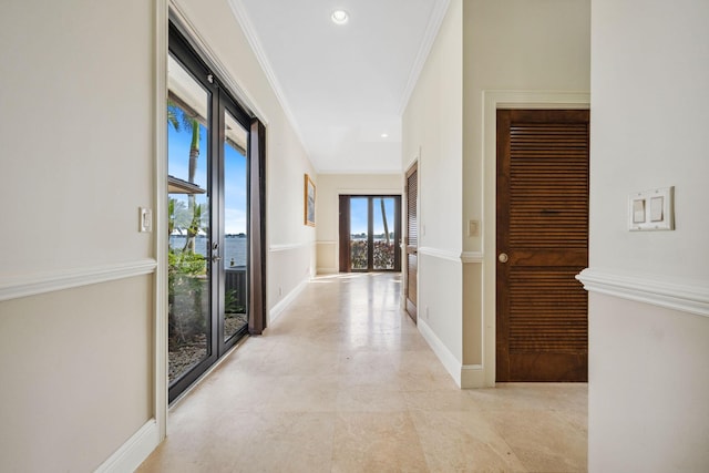 hallway featuring baseboards, crown molding, and recessed lighting