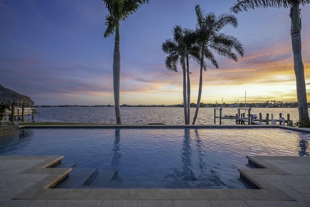 view of swimming pool featuring a water view, boat lift, and a dock