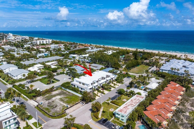 drone / aerial view featuring a water view and a beach view