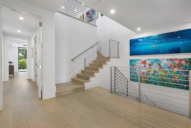 staircase with recessed lighting and wood finished floors