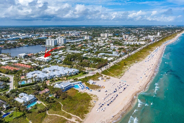 birds eye view of property with a water view, a view of city, and a beach view