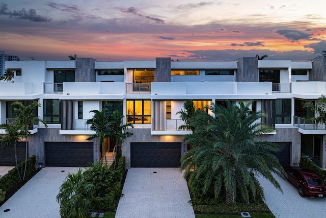 contemporary house with a garage, decorative driveway, and stucco siding