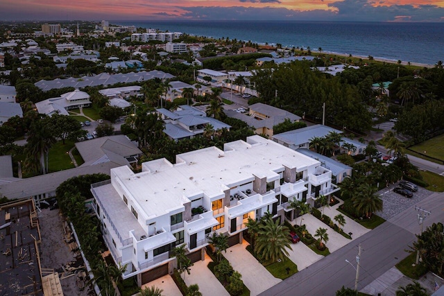 aerial view at dusk featuring a water view