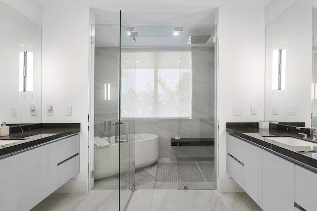 bathroom with visible vents, a sink, a freestanding tub, a shower stall, and two vanities