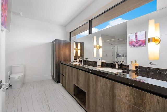 full bathroom with marble finish floor, double vanity, toilet, a stall shower, and a sink