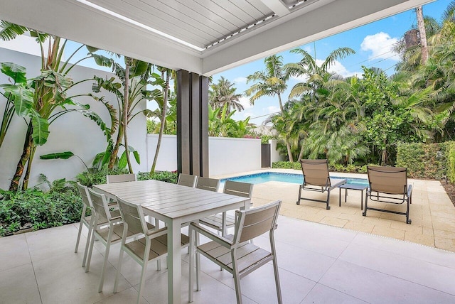 view of patio with a fenced in pool, outdoor dining space, and a fenced backyard