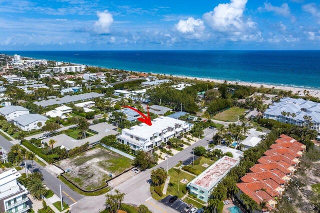 bird's eye view with a water view and a beach view