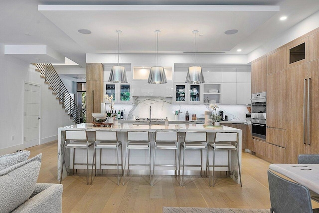 kitchen featuring light wood-style flooring, modern cabinets, and a breakfast bar area