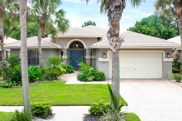 mediterranean / spanish-style house featuring a front lawn and a garage