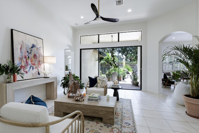 living room featuring ceiling fan, a towering ceiling, and light tile patterned floors