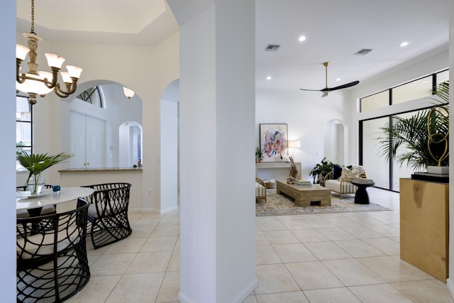 interior space featuring ceiling fan with notable chandelier and light tile patterned flooring