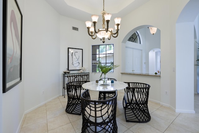 dining space featuring light tile patterned floors and an inviting chandelier