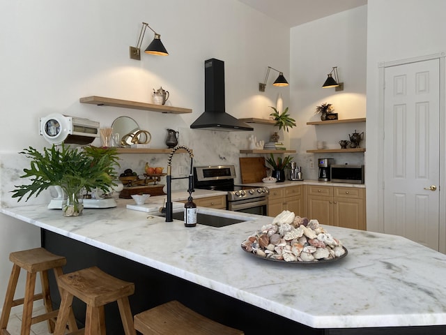 kitchen featuring kitchen peninsula, appliances with stainless steel finishes, sink, a breakfast bar area, and range hood