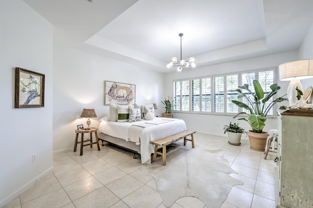 bedroom featuring a tray ceiling, multiple windows, and a chandelier