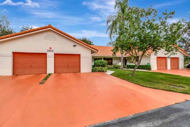 mediterranean / spanish home with a front lawn and a garage