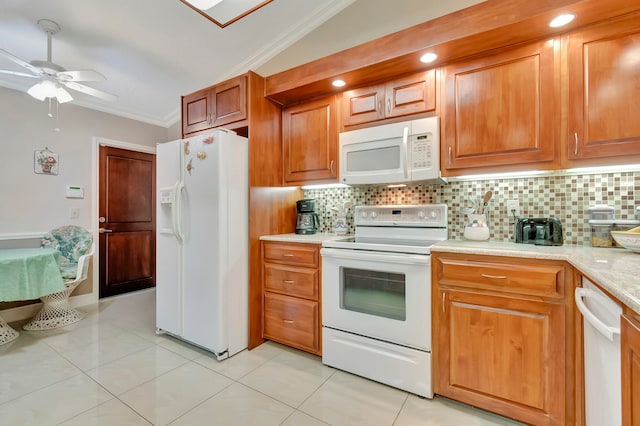 kitchen with light tile patterned flooring, vaulted ceiling, white appliances, crown molding, and ceiling fan