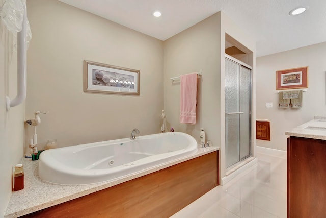 bathroom featuring shower with separate bathtub, vanity, and tile patterned floors