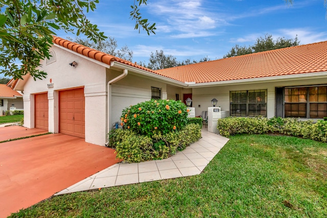 mediterranean / spanish-style home featuring a front lawn and a garage