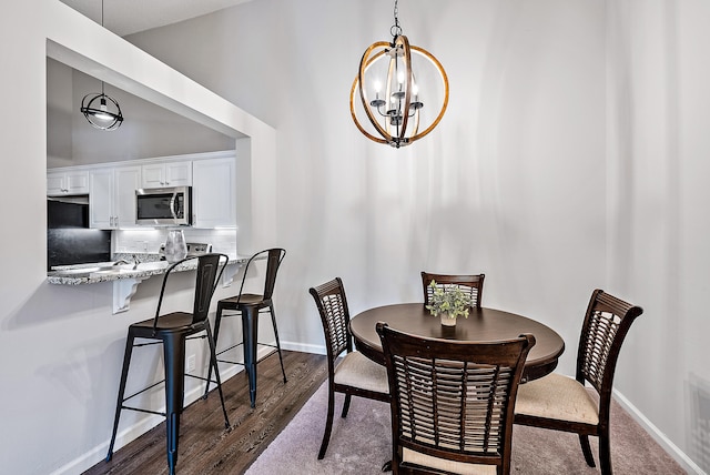 dining area with dark hardwood / wood-style floors and a chandelier